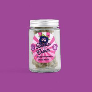 A clear glass jar of Kapow Berries "Berries & Cream" flower. The nugs inside are purple and frosty, featuring orange pistils.